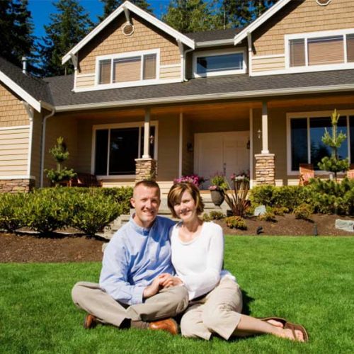 happy couple in front of hom