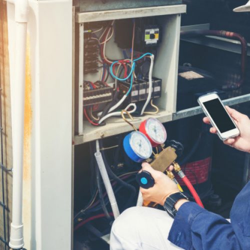tech performing maintenance on ac unit