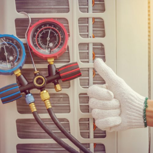 tech performing maintenance on ac unit